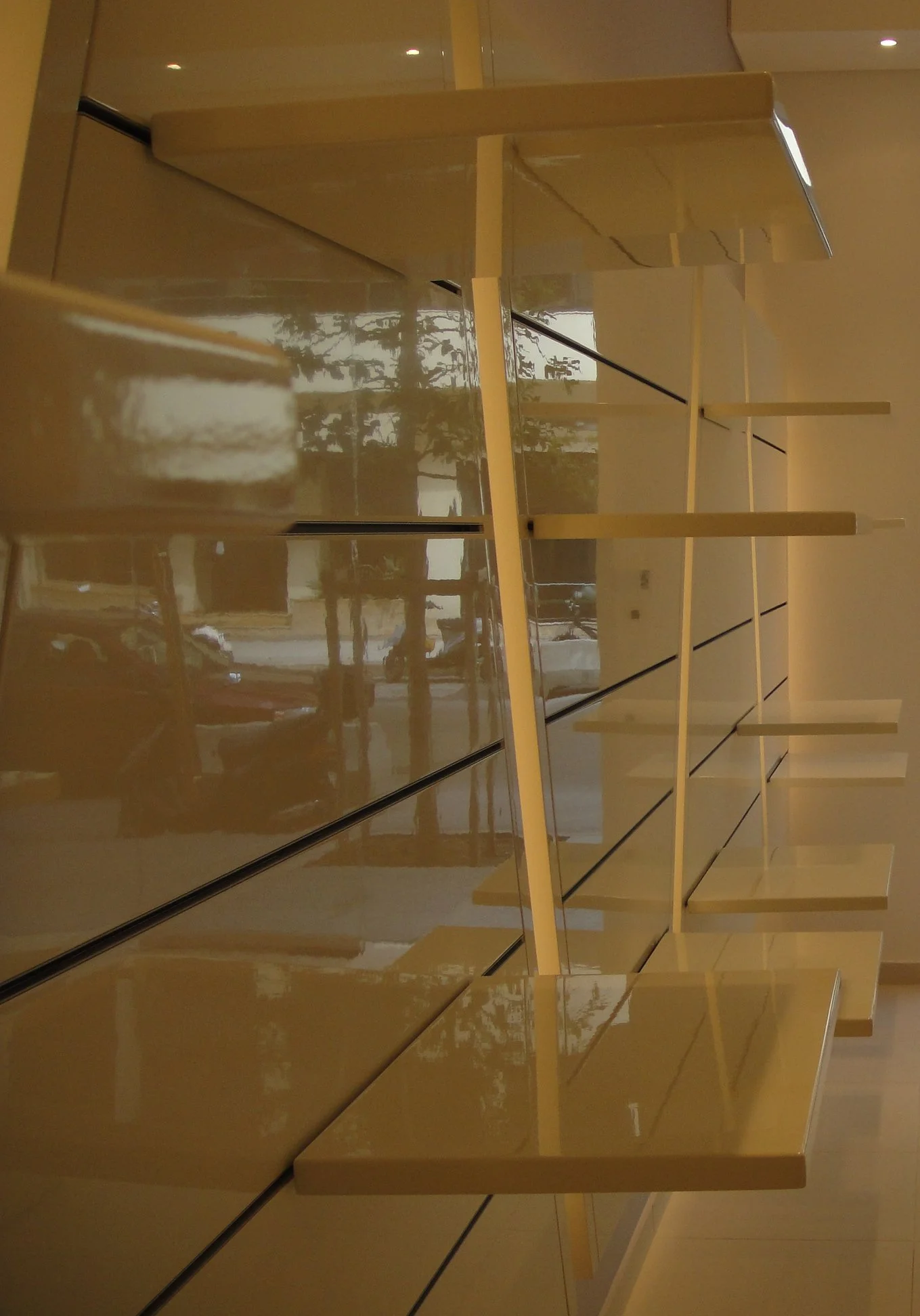 Empty wooden display shelves in a store, reflected in mirrored wall panels.