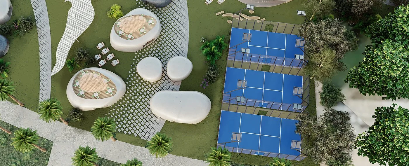 Aerial view of a recreational outdoor area with two gated tennis courts and uniquely shaped white lounge structures surrounded by trees and pathways.