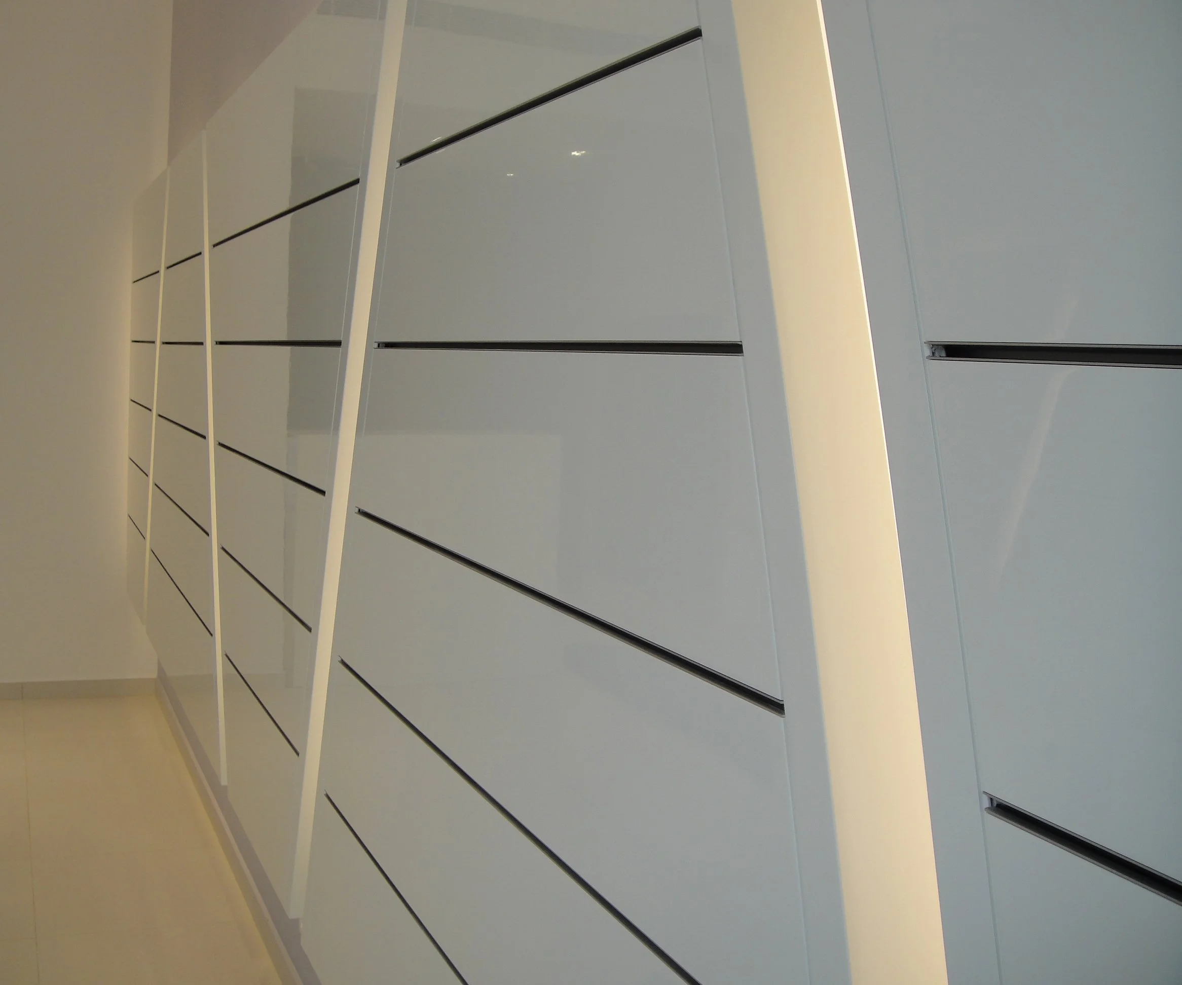 Interior view of a modern, minimalistic room with white walls and black horizontal lines, viewed from a low angle.