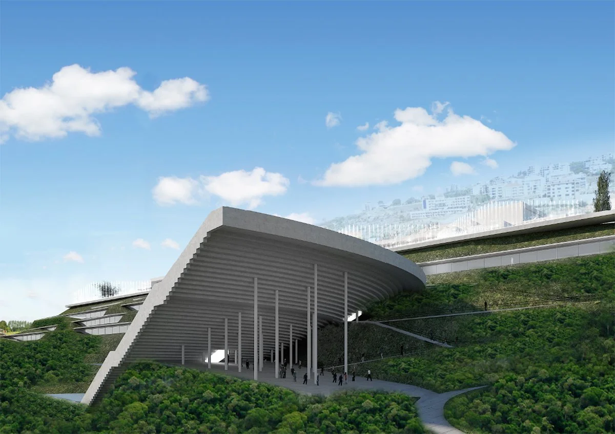 Modern architectural building with a curved roof supported by tall columns, situated on a green hillside with pathways and people walking underneath.