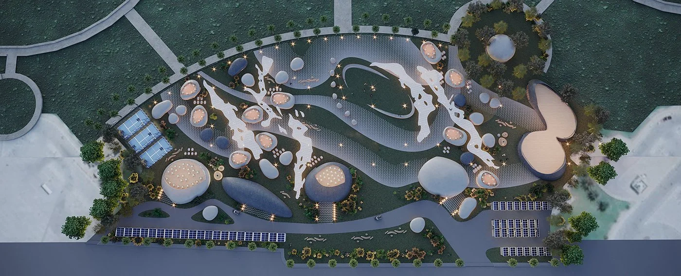Aerial view of a modern, artistically designed outdoor space with abstract patterns, circular and irregular shapes, pathways, trees, and small structures, illuminated by many lights at dusk or night.