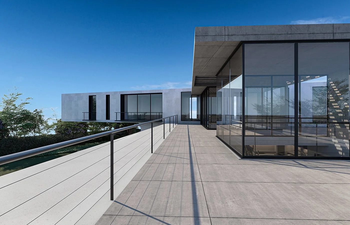 Modern building with large glass windows and a spacious outdoor balcony under a clear blue sky.