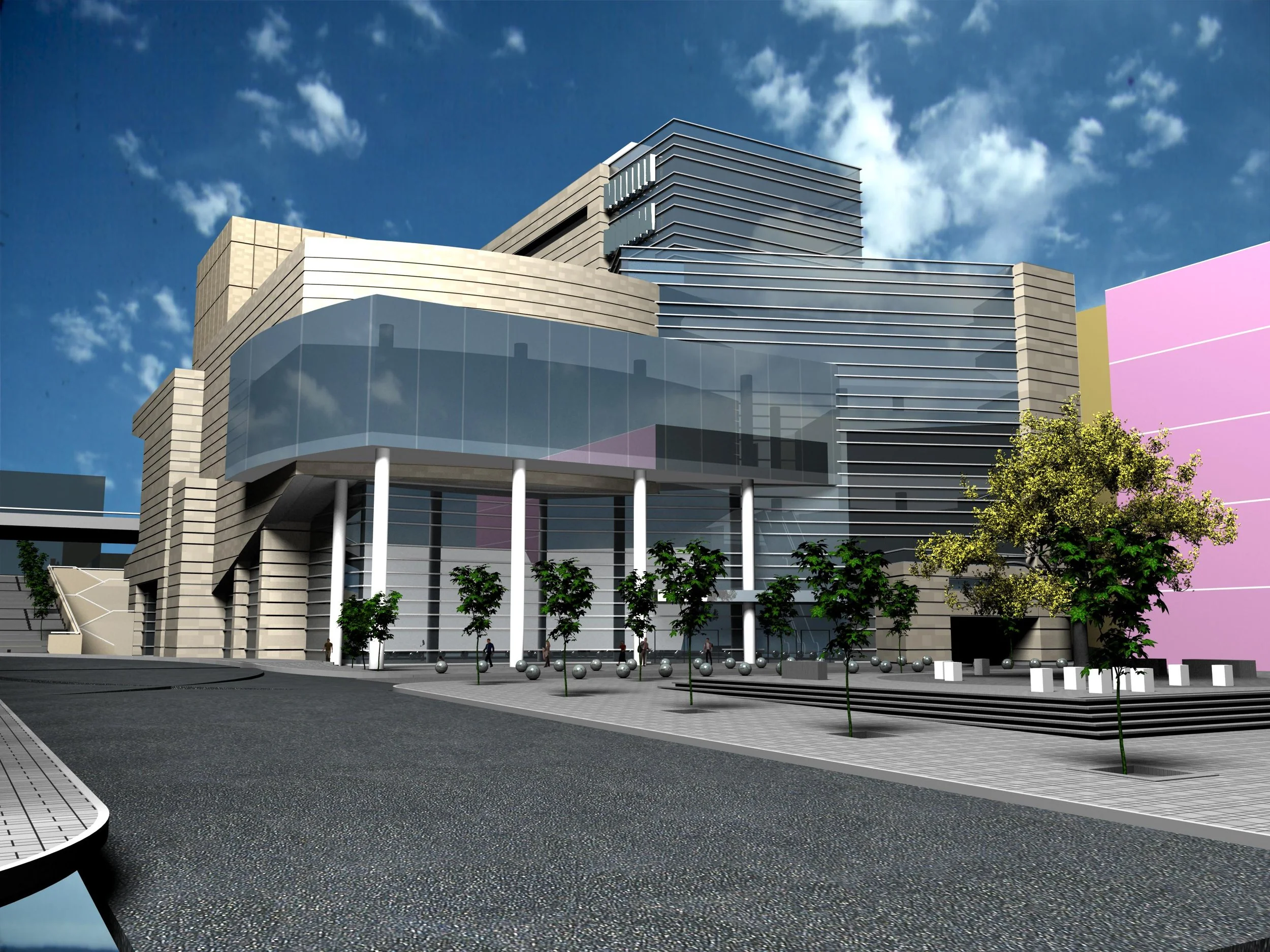 A modern multi-story building with reflective glass windows, horizontal lines, and a mix of beige and gray exterior materials. There are trees and a paved pedestrian area with bollards in the foreground.