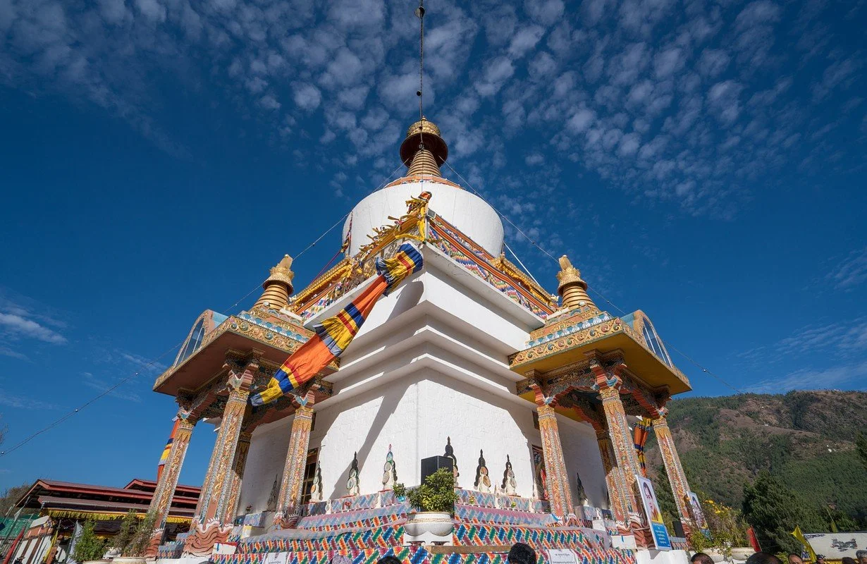 Georgia, Guduari. Ancient stone church on a snow-covered hill with a mountainous, snow-covered background.