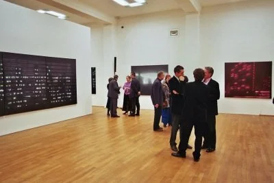 Menschen betrachten und diskutieren Kunstwerke in einer Galerie.