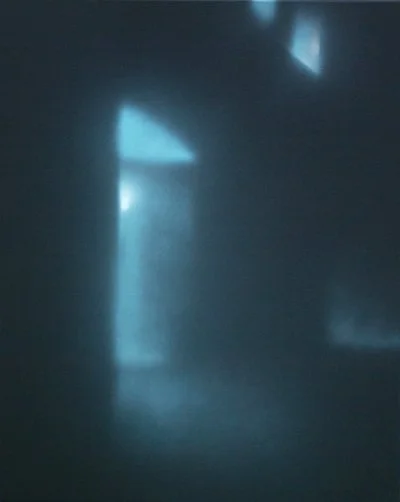 Schwer erkennbare dunkle Szene mit bläulichem Licht und unscharfen Formen.