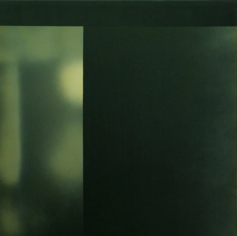 Ein dunkler, grüner Raum mit einer Wand, auf der ein Glasfenster zu sehen ist, das Licht hereinlässt.