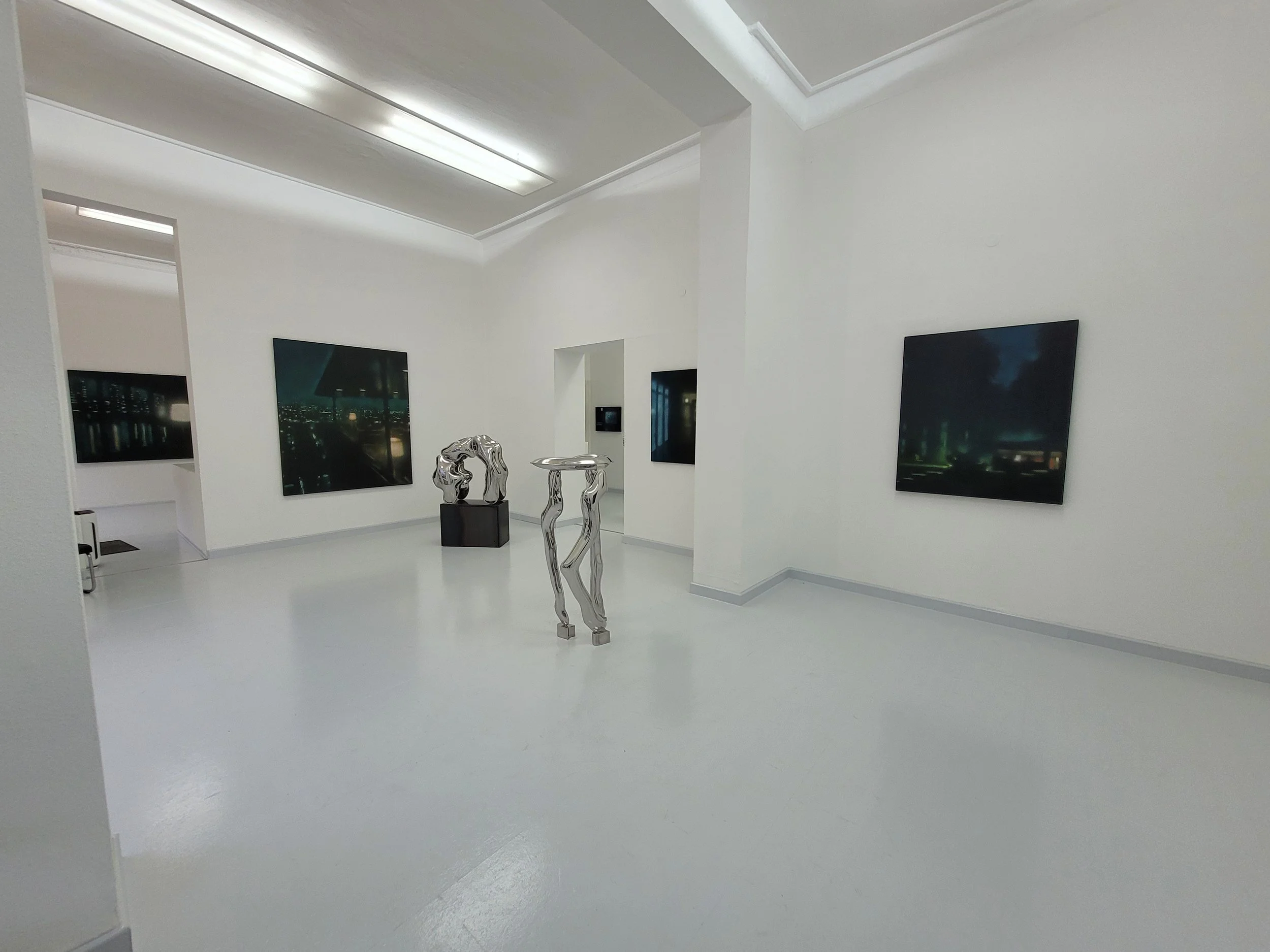 Ein Kunstmuseum mit weißem Raum, modernen Skulpturen und erstklassigen Gemälden an den Wänden.