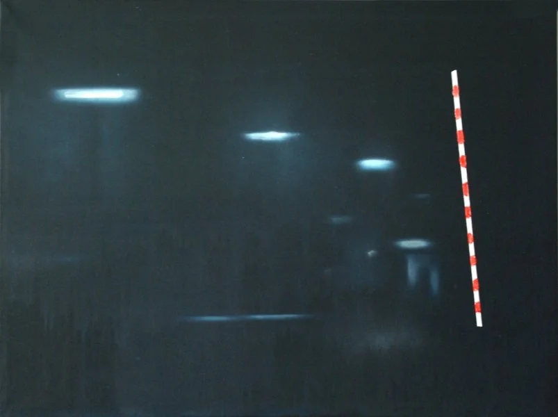 Nachtaufnahme mit mehreren Straßenlaternen und einer rot-weiß gestreiften Barriere auf der rechten Seite.