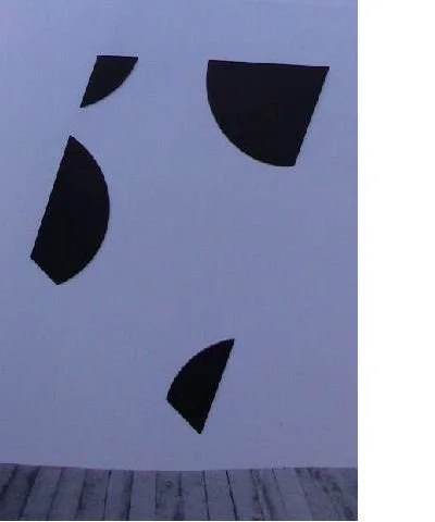 Abstrakte schwarze Formen auf weißer Wand