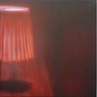 Ein rotes Lampenschirm in einem dunklen Raum.