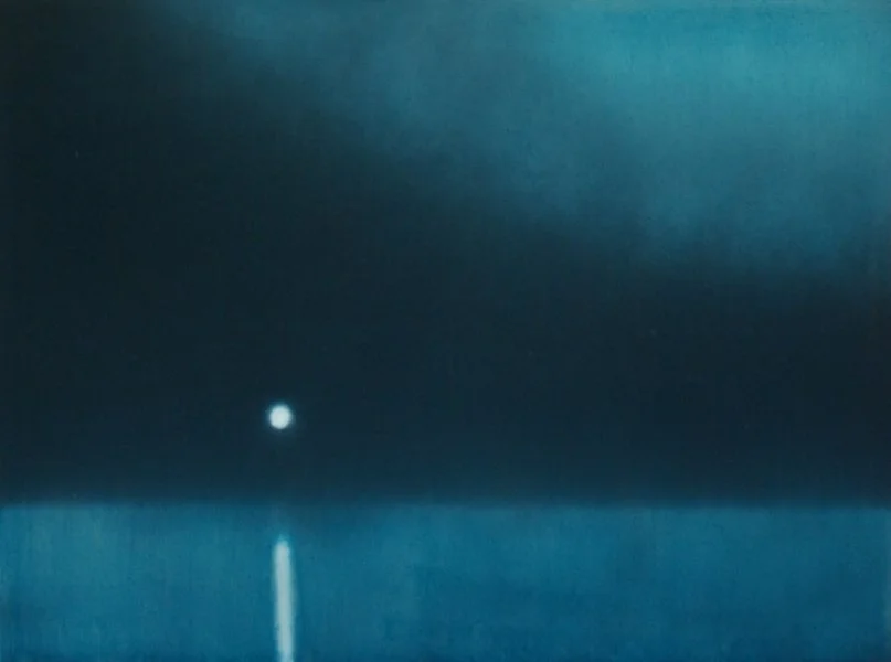 Der Himmel über einem Ozean bei Nacht mit einem einzelnen leuchtenden Punkt, der wahrscheinlich ein Stern oder Planeten ist.