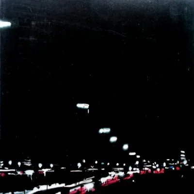 Nachtaufnahme von einer beleuchteten Straße mit Fahrzeugen und Straßenlaternen.