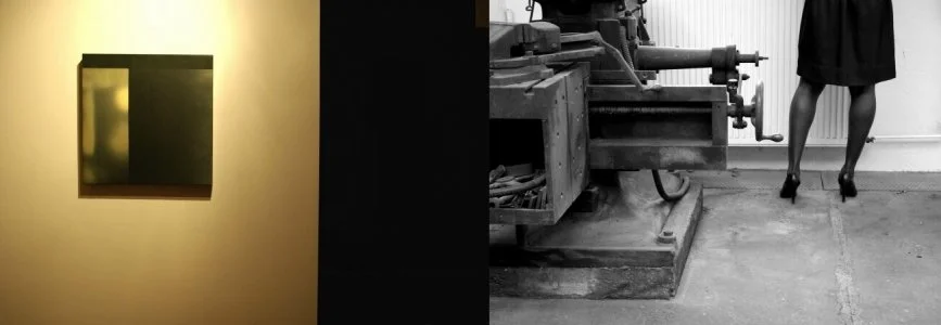 Ein Gemälde an einer gelblich beleuchteten Wand, neben einer dunklen Wand, und auf der anderen Seite ein schwarzer und weißer Abschnitt mit einem Teil einer Maschine und den Beinen einer Frau in schwarzen High Heels und Rock.