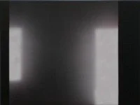 Ein dunkler Raum mit zwei hell erleuchteten Fenstern oder Lichtquellen auf gegenüberliegenden Seiten.