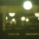 Unscharfer Blick auf eine dunkle Straße mit Straßenlaternen bei Nacht.