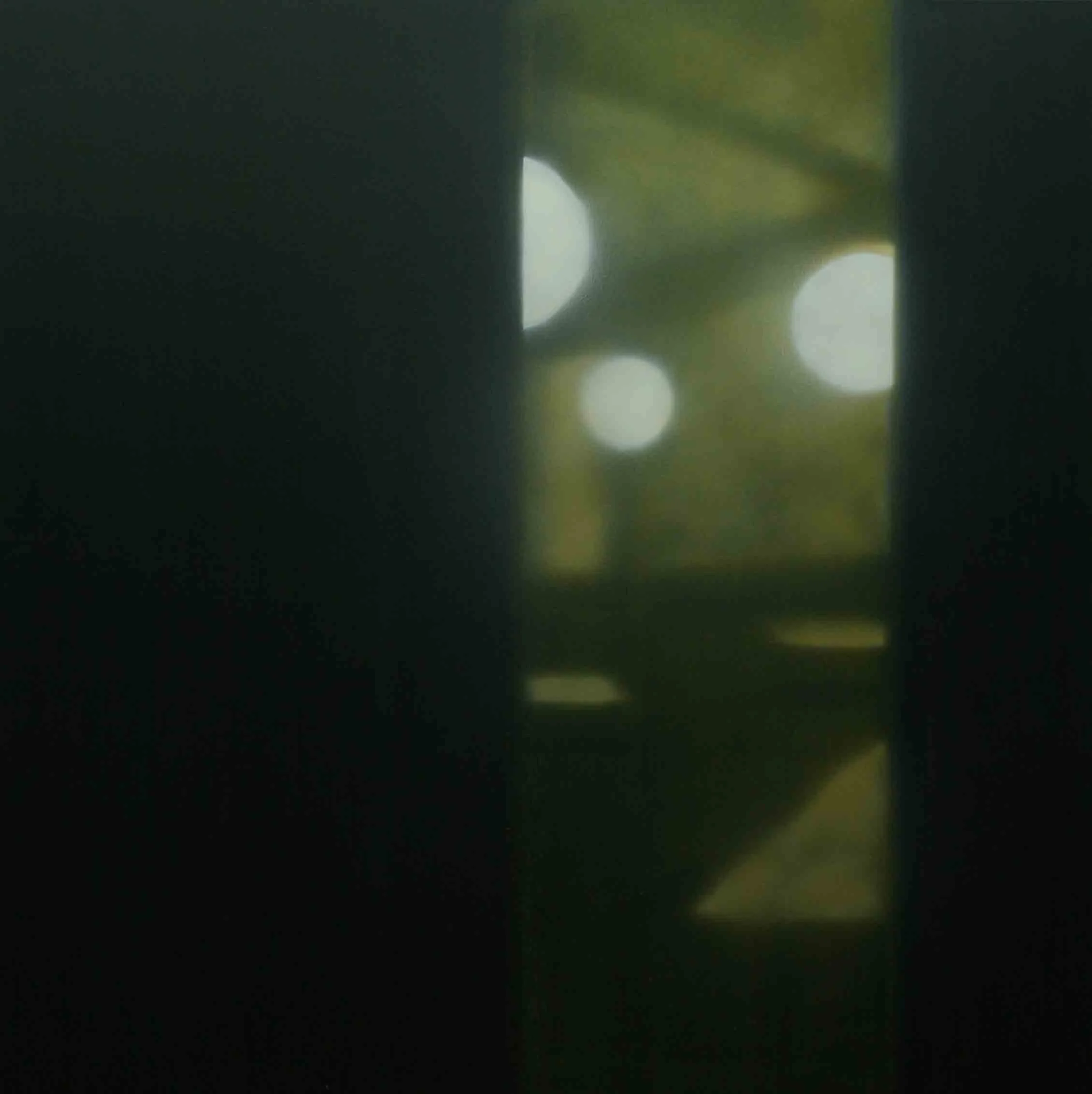 Unscharfer Blick durch eine Tür oder Fenster auf eine im Hintergrund sichtbare helle Lichter und einen Baum oder Sträucher.