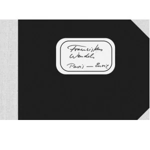 Schwarz-weißer Notizblock mit handgeschriebener Notiz und der Aufschrift 'Französisches Wunder, Paris - Berlin'