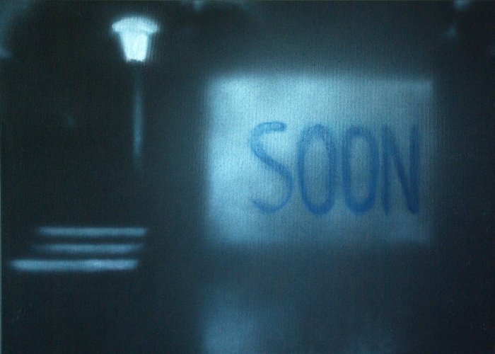 Ein beleuchteter Aufkleber mit dem Wort 'SOON' auf einer dunklen Oberfläche