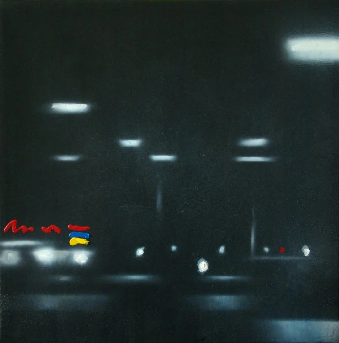 Dunkle Straße bei Nacht mit reflektierenden Straßenlaternen und Auto-Scheinwerfern, einige kleine bunte Lichter im unteren linken Bereich.