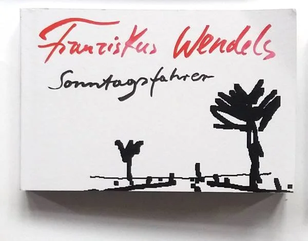 Buchcover mit handgeschriebener Schrift: 'Frauizkus Wendels Sonntagsfahrer' und einer einfachen schwarzen Illustration zweier Bäume.