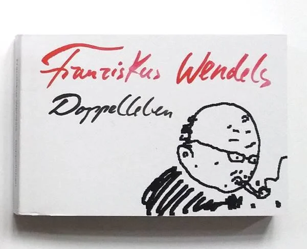 Buchumschlag mit handschriftlichem Titel und einem Strichmännchen, das eine Pfeife raucht.