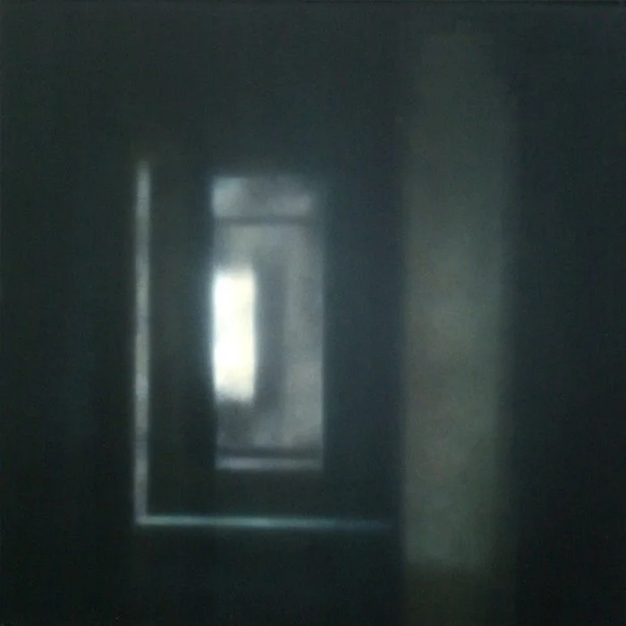 Ein dunkler Korridor mit einem Fenster am Ende, durch das Licht einfällt.