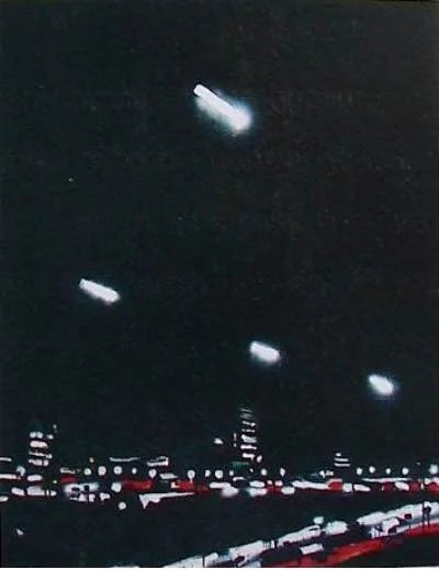 Nachtaufnahme mit mehreren Flugzeugen über einer Stadt mit beleuchteten Gebäuden und Straßen.