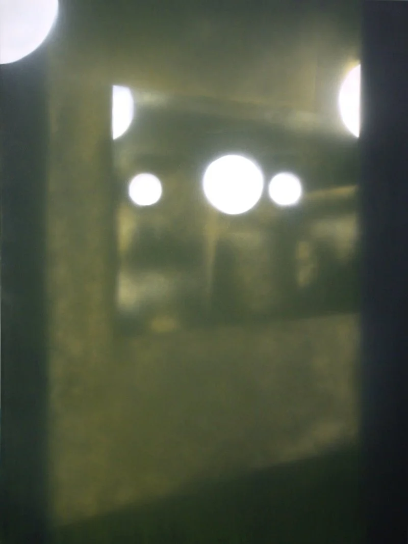 Blick durch ein Loch in einer Wand oder Tür, durch das mehrere Lichtquellen sichtbar sind.