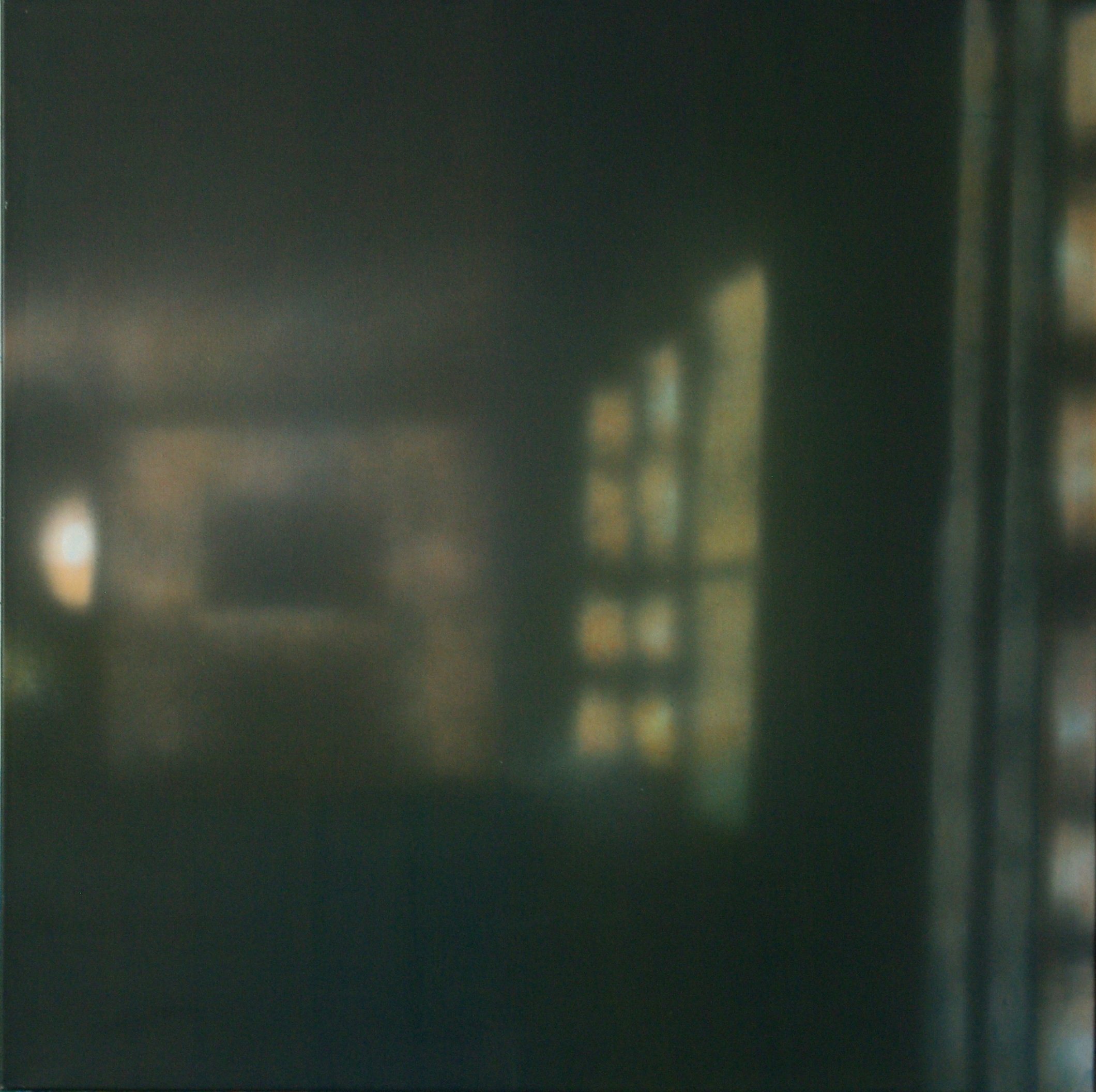 Ein unscharfes, dunkles Bild mit spiegelnden Lichtreflexen und Fenstern im Hintergrund.