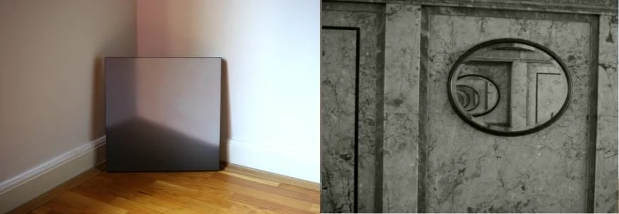 Ein schwarzes Quadrat und ein strahlenförmiges Design an einer grauen Mauer, aufgenommen im Innenraum.