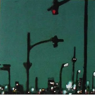 Stadtbild bei Nacht mit Verkehrampeln und Gebäuden.