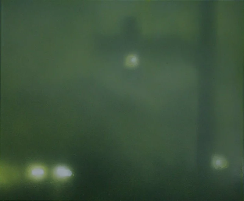 Das Bild zeigt eine dunkle, grüne Wand mit zwei kleinen hellen Lichtpunkten im unteren Bereich und einem einzelnen hellen Lichtpunkt in der oberen Mitte.