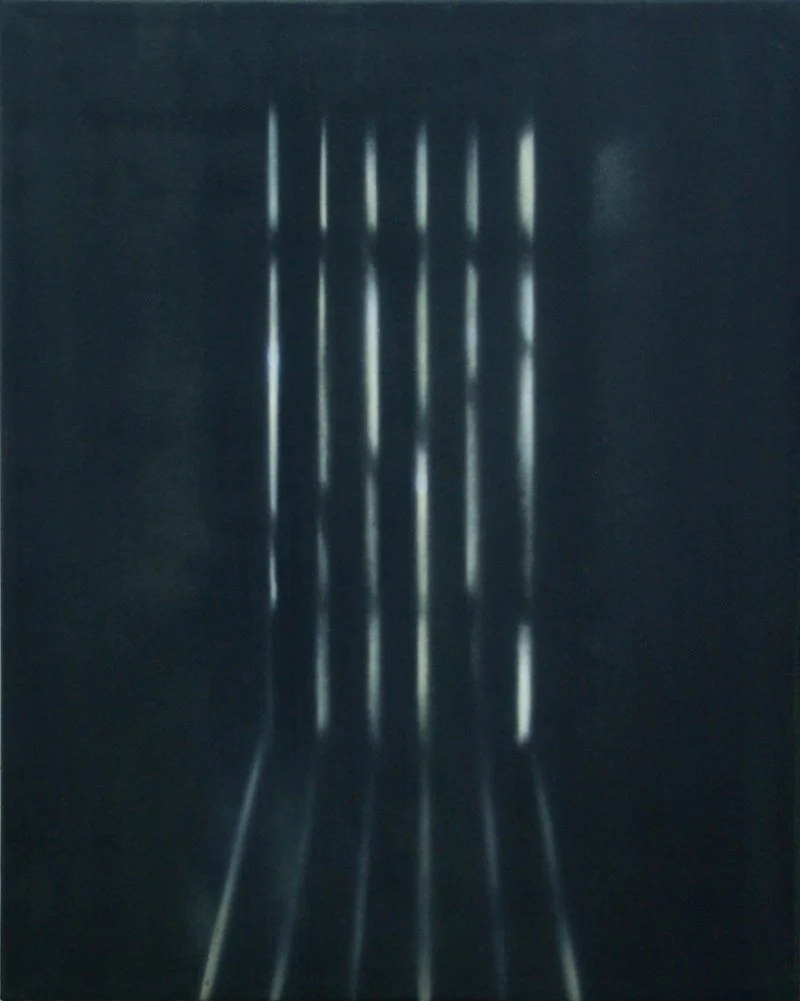 Lichtstrahlen, die durch schmale Ritzen in einer dunklen Oberfläche scheinen.