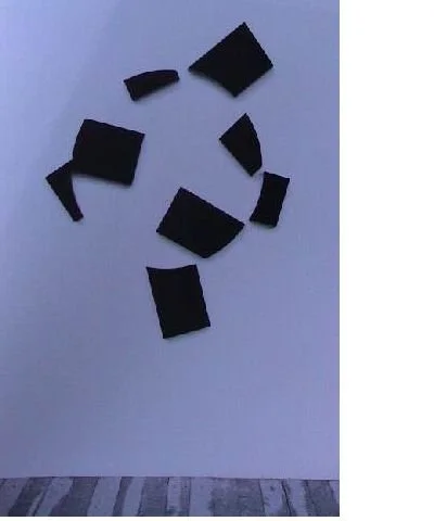 Schwarze Puzzlestücke auf weißer Wand