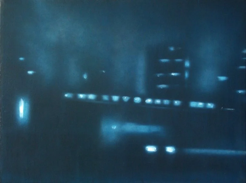 Das Bild zeigt eine nächtliche Straßenaufnahme mit leuchtenden Scheinwerfern und reflektierenden Lichtern auf nasser Straße.