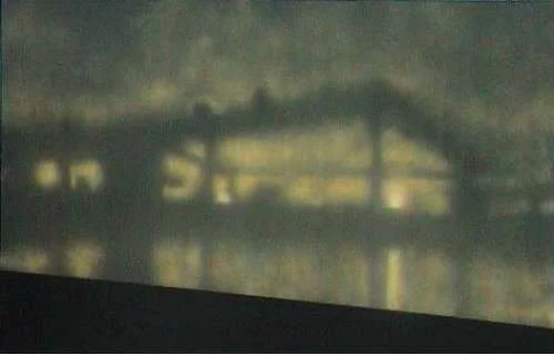 Schwer erkennbare, dunkle und unscharfe Aufnahme eines Gebäudes bei Nacht.