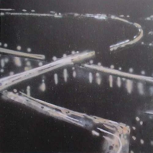 Lichterketten in einer verschlungenen Anordnung, beleuchtet und reflektiert auf einer dunklen Oberfläche.