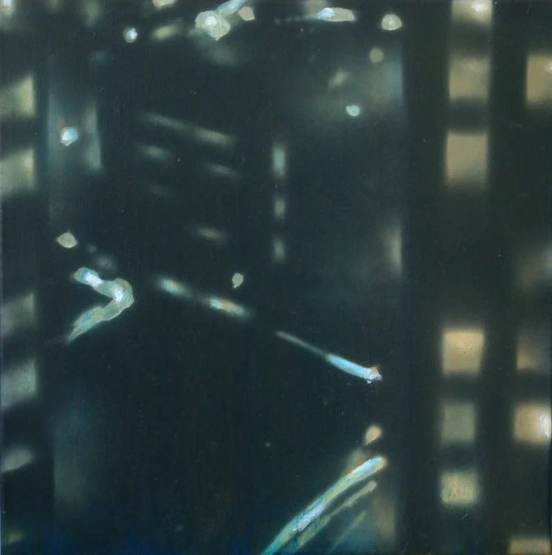 Nahaufnahme von einer dunklen Oberfläche mit herausgestreckten Kabeln oder Drähten darunter, im Hintergrund unscharfe Lichter und Strukturen.