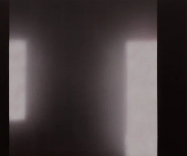 Ein dunkler Raum mit zwei Lichtquellen, die auf die Wände scheinen.