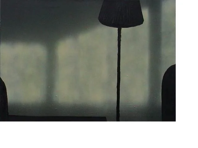 Ein Standbrenner mit einem schwarzen Lampenschirm und einem Kabel als Ständer, vor einer hellen Wand.