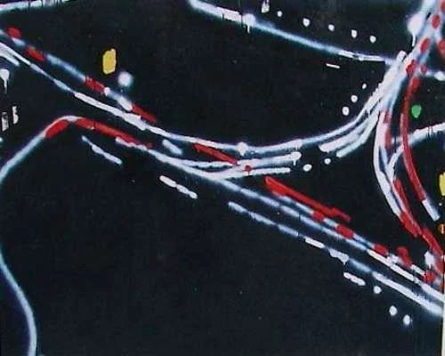 Nahaufnahme von bunten Lichtern auf einer dunklen Straße bei Nacht, wahrscheinlich eine Aufnahme von einem beleuchteten Straßenabschnitt.