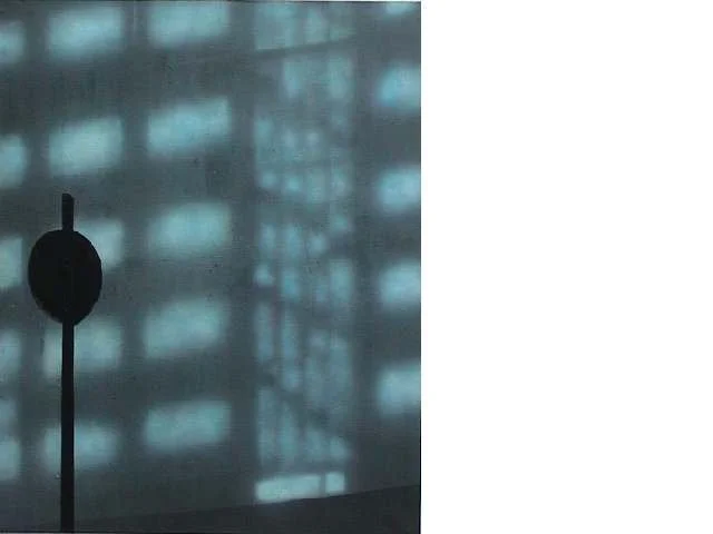 Ein Wasserhahn vor einem Fenster mit einem Gebäudebild im Hintergrund.