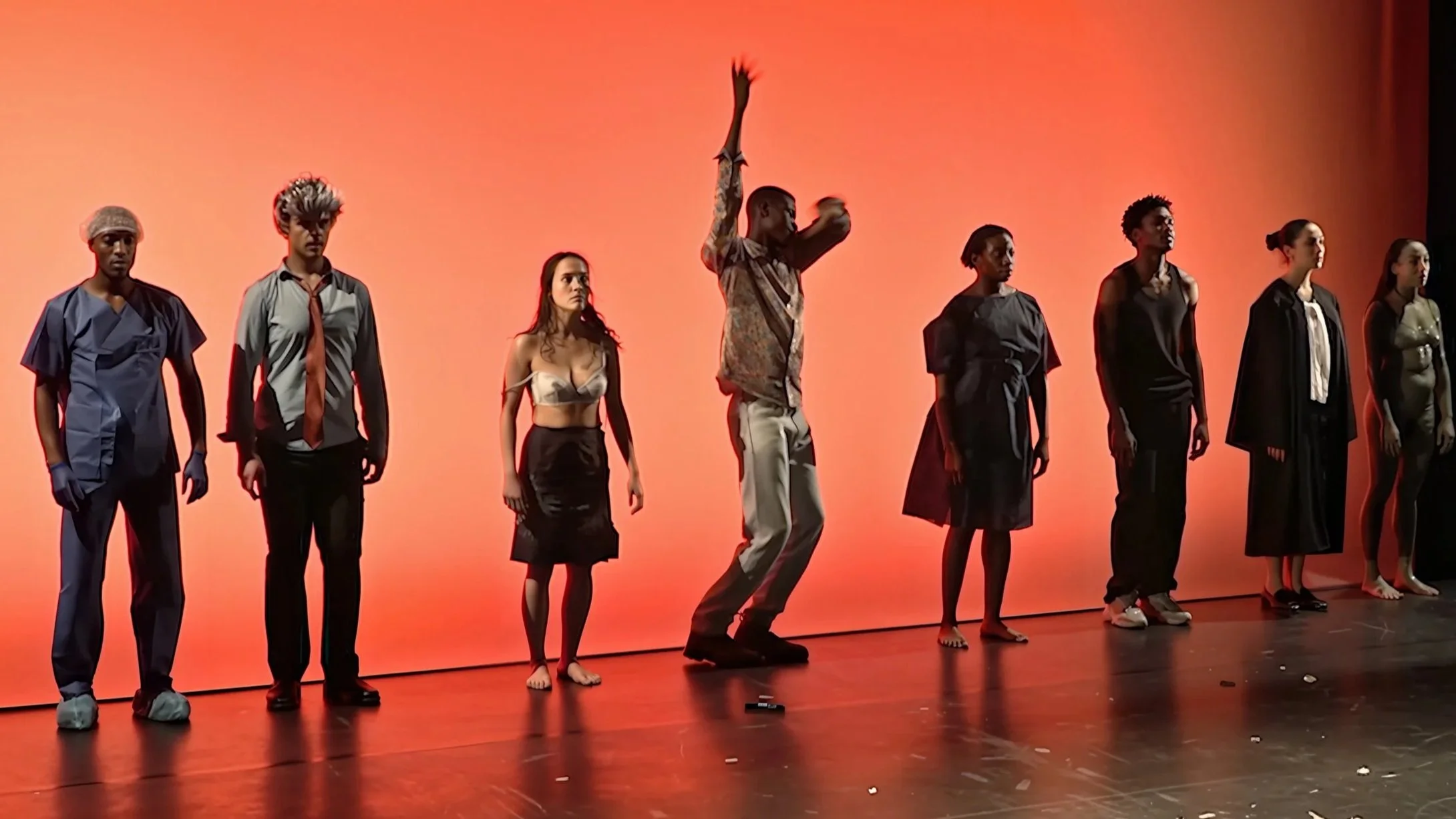 Scènes d'un spectacle avec plusieurs personnes en tenue variée contre un fond orange.