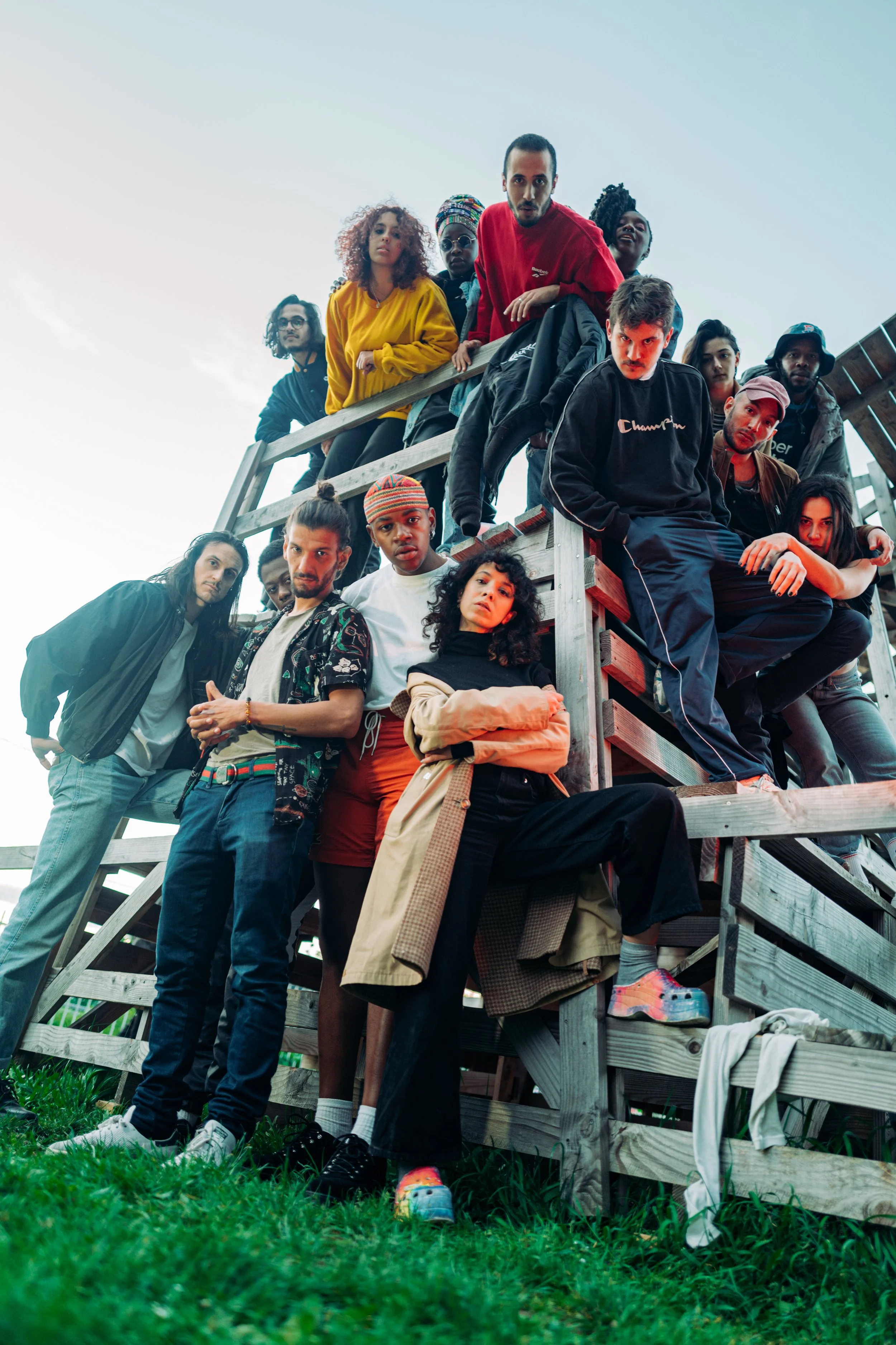 Groupe de jeunes adultes posant sur une structure en bois lors d'une séance photo en plein air
