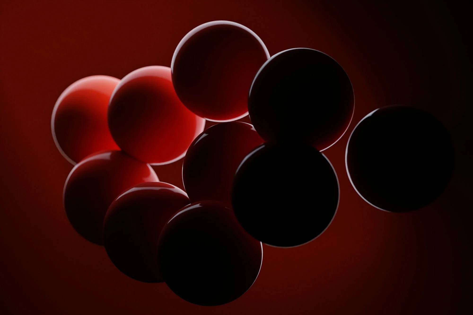 Image of several black and red spheres arranged against a dark red background, with some spheres backlit to highlight their edges.