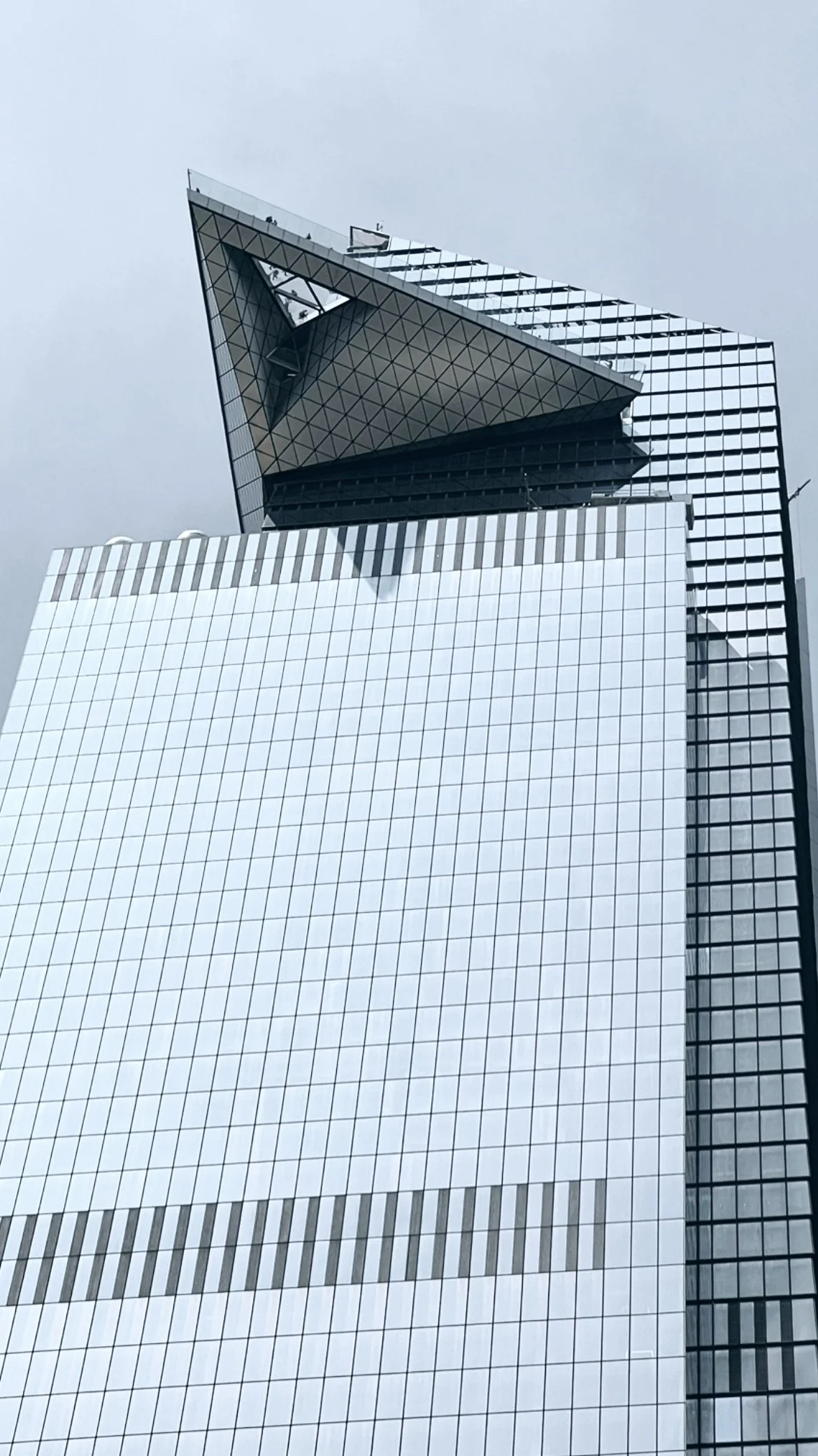 A modern skyscraper with a distinctive irregular angular top, made of reflective glass panels.