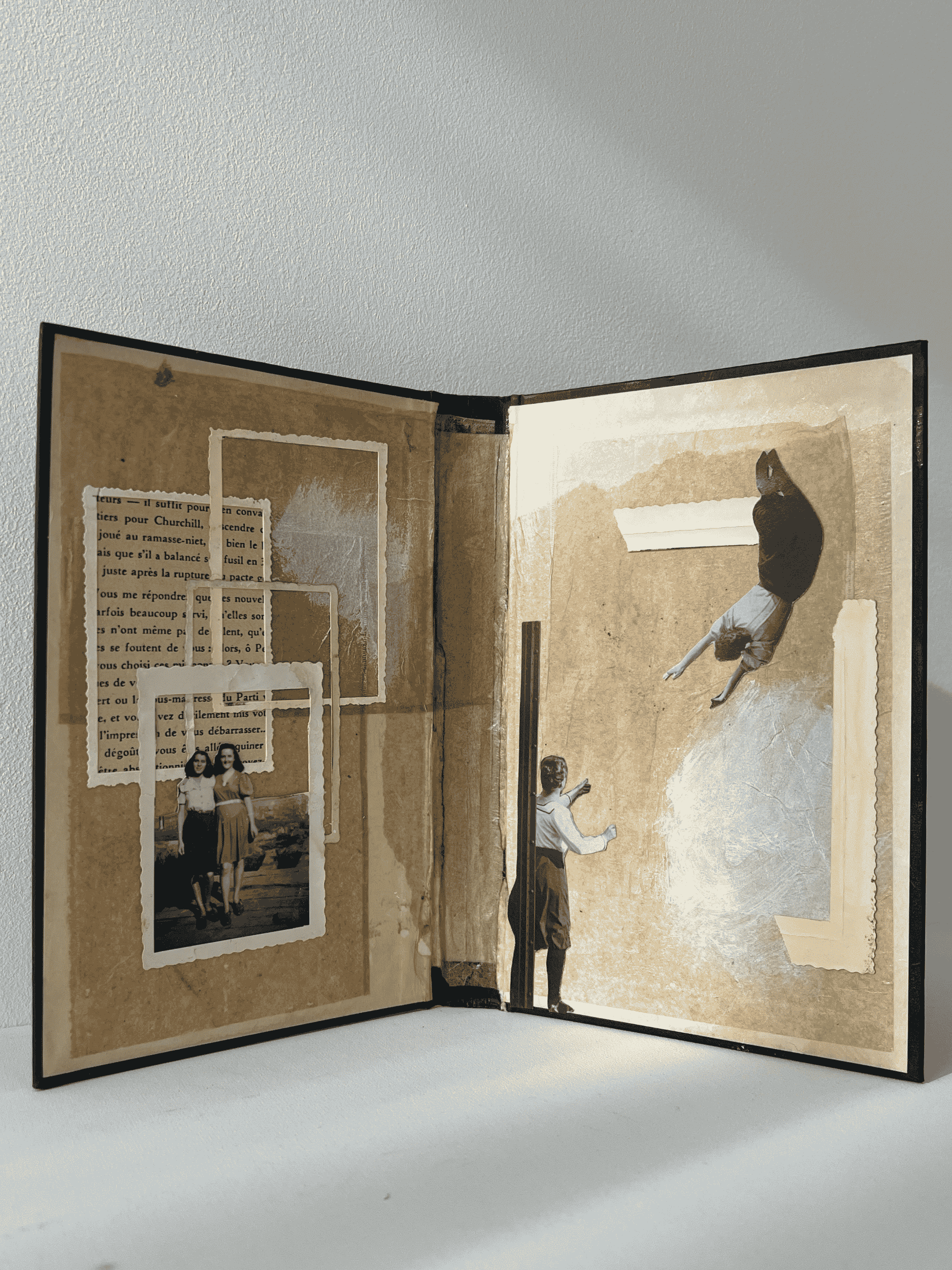 An open vintage scrapbook with black-and-white photos and cut-out images of children playing and a woman sitting upside down, arranged on textured, aged paper.