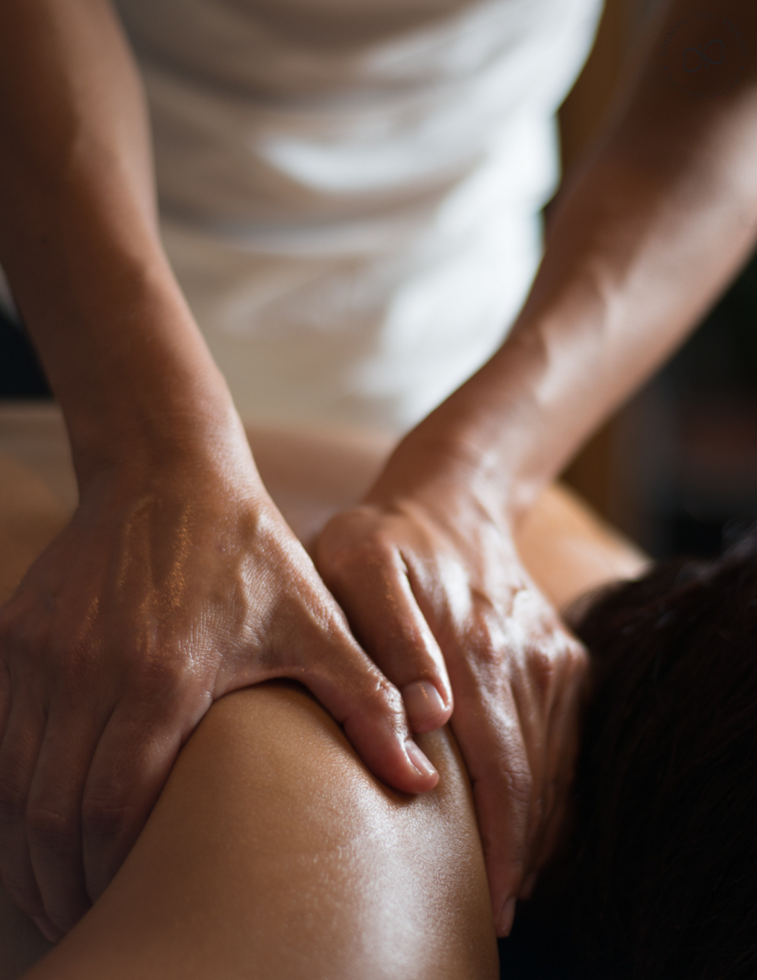 A person receiving a massage, focusing on their shoulder and upper arm.