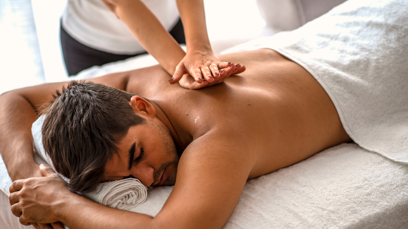 Man receiving a back massage from a massage therapist in a spa or wellness center.